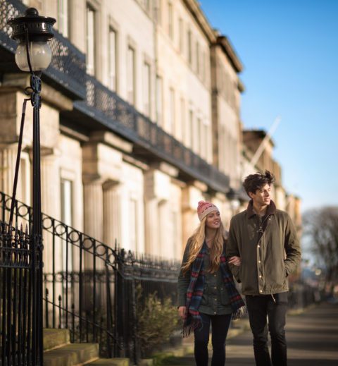 Una giovane coppia cammina su Regent Terrace a Edimburgo in Scozia