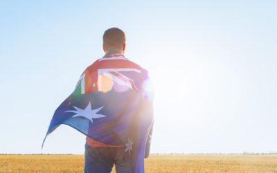 Man with a flag of Australia standing in morning field