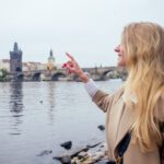 woman with an appetite eats a traditional The Charles Bridge feed the swans with trdlo or trdelnik in Prague sity in Chezh.